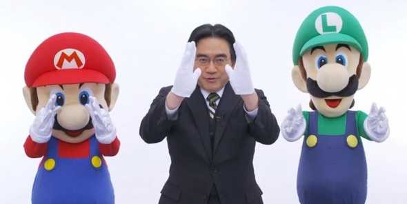 Iwata holding a Nintendo 3DS